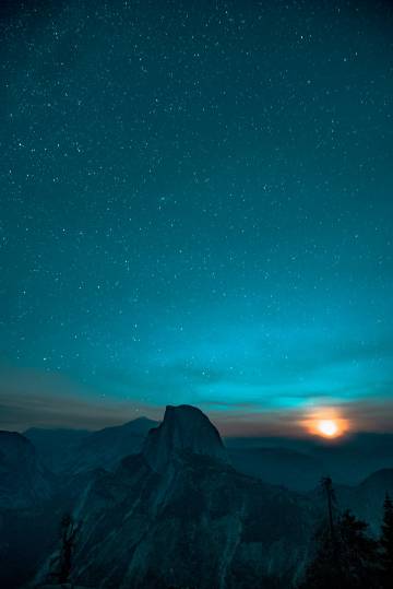 A newly risen moon over half dome phone wallpaper