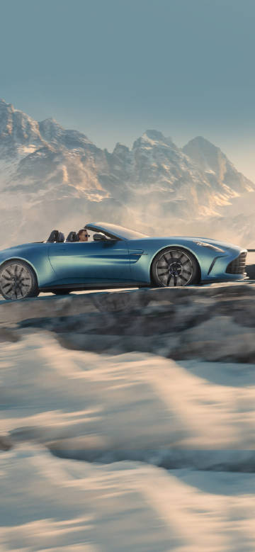 Convertible sports car driving in the snowy mountains phone wallpaper
