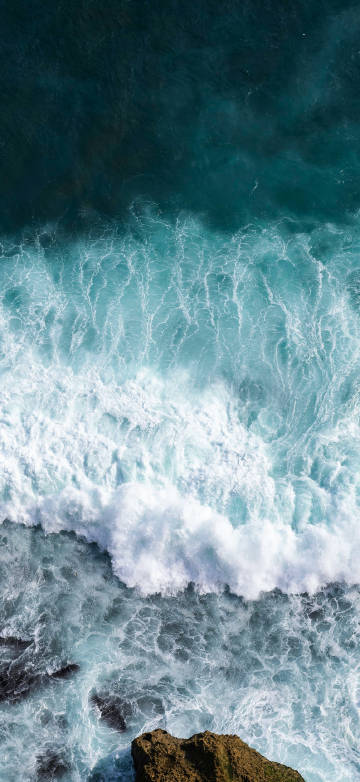 Waves blowing against the rocks by the sea 4k phone wallpaper