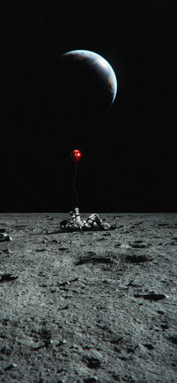 Astronaut lying on the moon and releasing red balloon