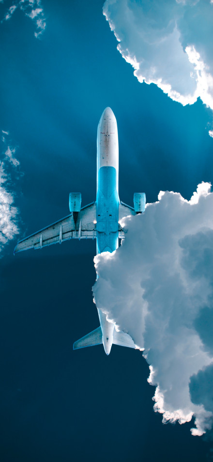 An airplane flying through the white clouds phone wallpaper
