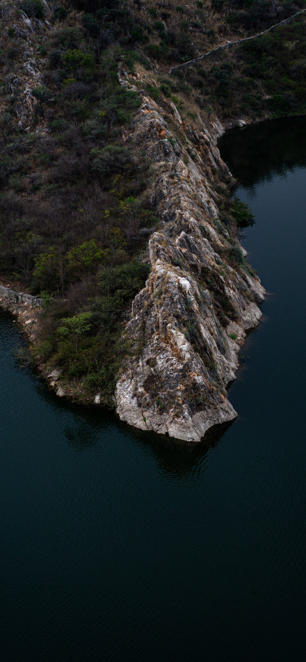 Dark Waters Meet Rugged Cliffs Phone Wallpaper