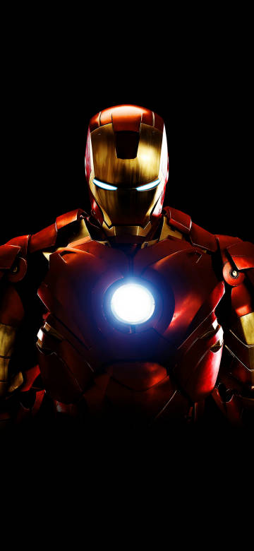 Iron Man Standing in Darkness with Glowing Chest Light 4K Wallpaper