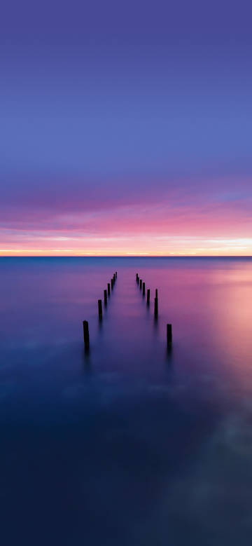 Twilight wooden pile on the tranquil sea
