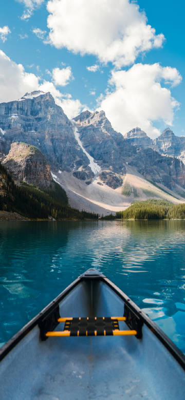 Small boat sailing under blue sky and white clouds