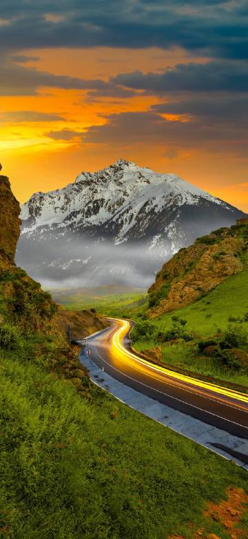 Snow mountain road scenery under sunset