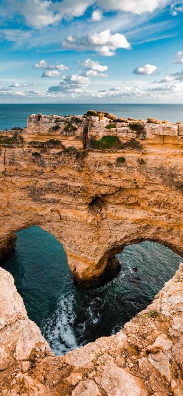 Amazing Cliff Caves under the Blue Sea and Sky