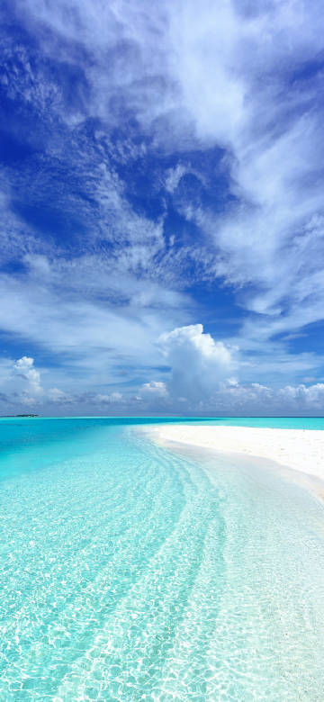 Clear sea water under blue sky and white clouds