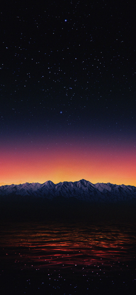 Snow - capped Mountains Reflecting in Water under the Stars