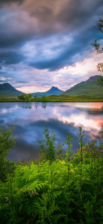 Tranquil mountain and lake view under cloud cover