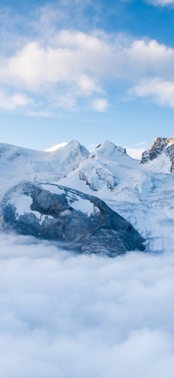 Snowy mountain scenery in a cloudy landscape