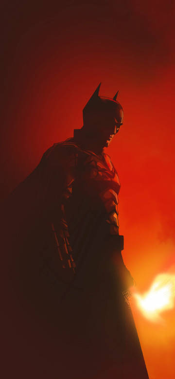 The silhouette of Batman in the glimmer of flames