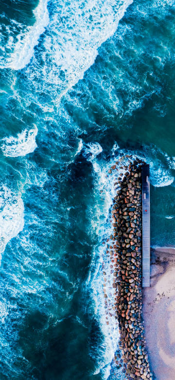 Surging waves beside the seaside stone embankment