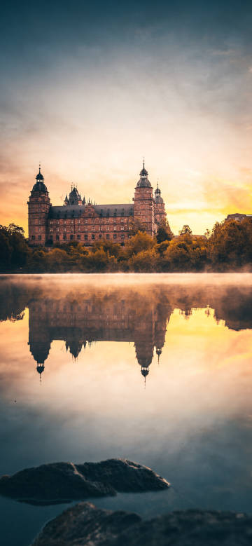 Castle reflection on lake at sunrise