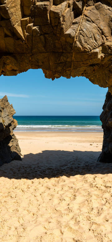 Beach scenery under rock arch