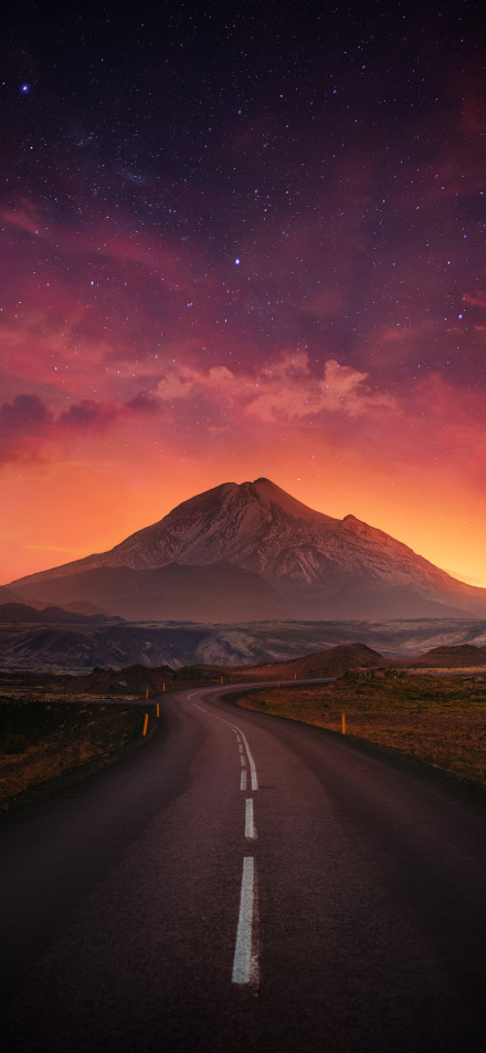 Mountain peaks under an orange starry sky