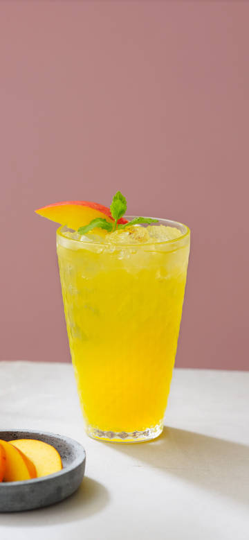 Cool iced beverage garnished with mango and mint
