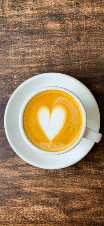 Heart shaped coffee on wooden table