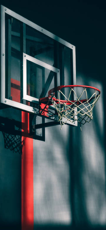 A close-up of a dark-toned basketball hoop