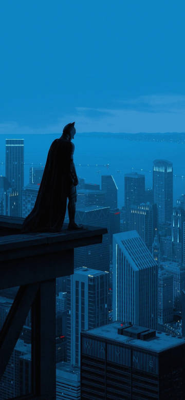 Batman standing on the edge of a tall building