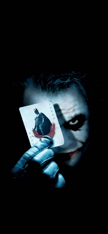 The Joker holds a Batman poker card