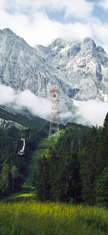 Cable car in forest and majestic mountain scenery