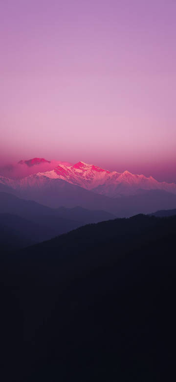 Snow mountain scenery against pink-purple sky