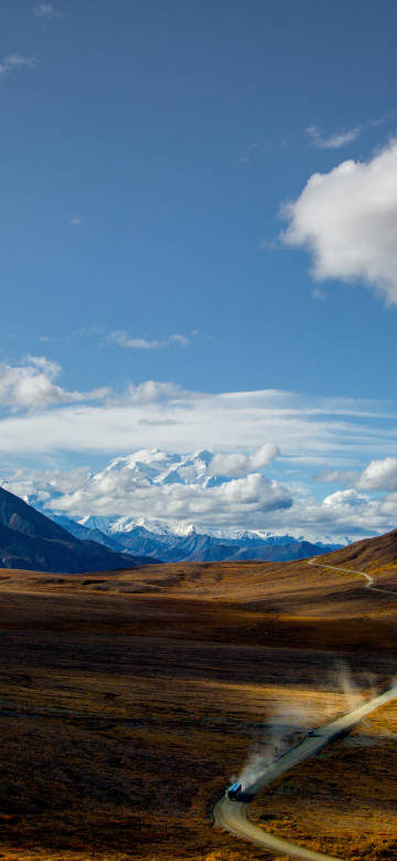 Wasteland road under snowy mountains