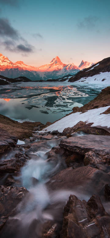 Beautiful sunrise over snowy mountain lake