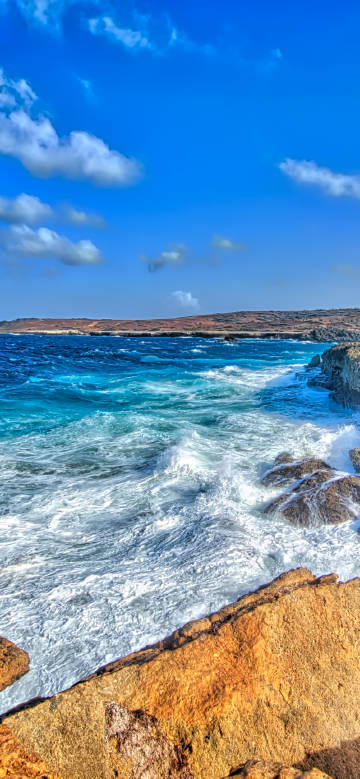Blue sky, white clouds, waves and rocks