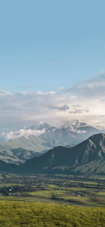 Beautiful mountain ranges and grassland under snowy peaks