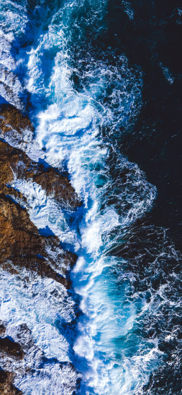 Aerial view of waves crashing against rocks