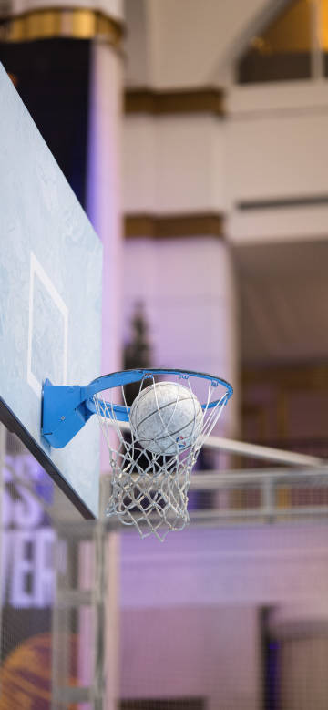 Basketball going into the hoop in an indoor court