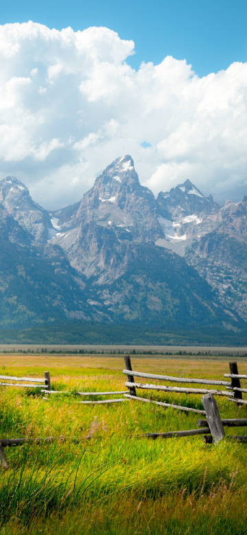 Majestic snow-capped mountains by the prairie fence