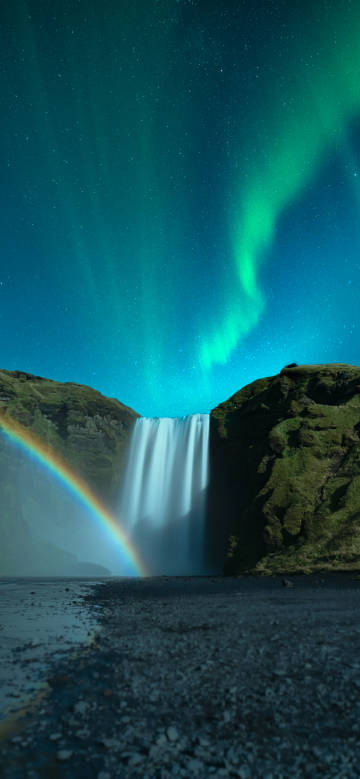 Green aurora in the night sky with waterfall and rainbow
