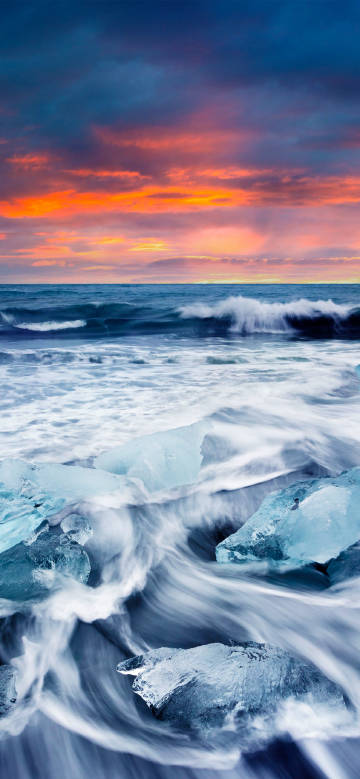 Waves and ice under gorgeous sunset