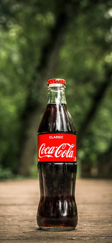 A bottle of classic Coca-Cola on the ground