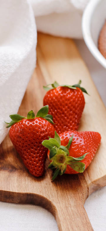 Strawberries close up on wooden cutting board