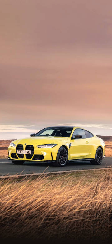 Yellow bmw m4 sports car on the road phone wallpaper
